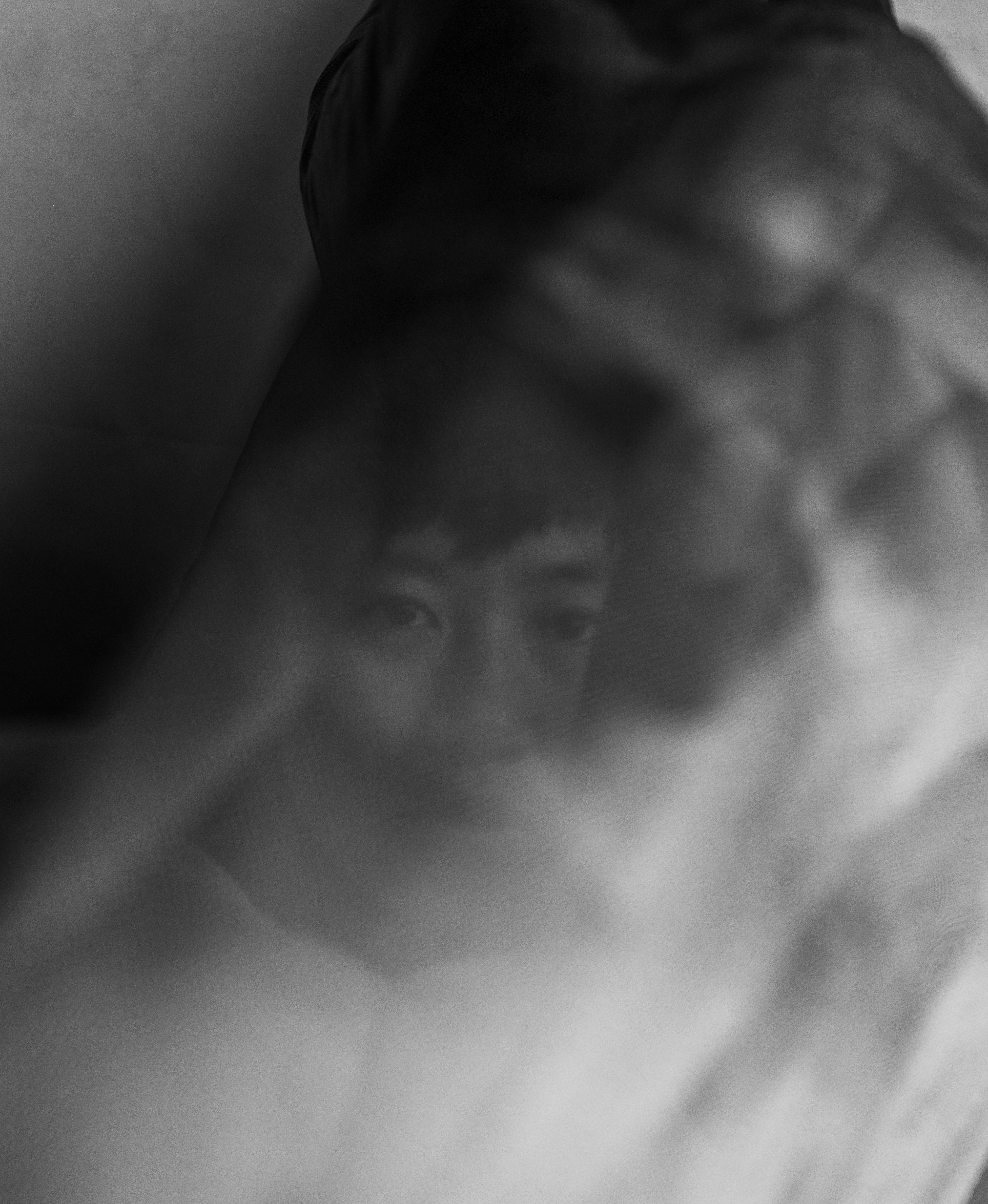 Held in the Blur portrait with fabric obscuring the face